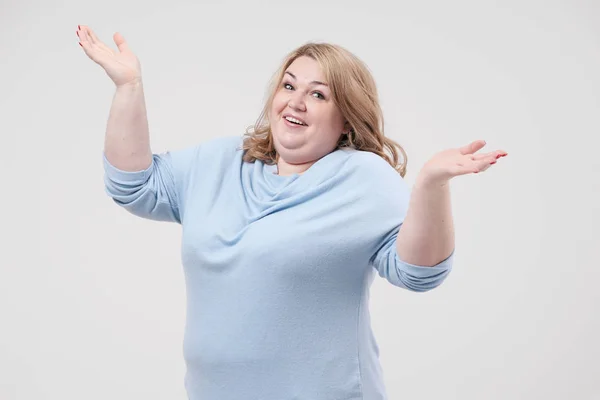 Молодая толстая женщина в повседневной голубой одежде на белом фоне в студии. Позитивный . — стоковое фото