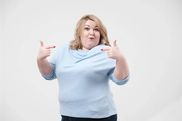 Jonge zwaarlijvige vrouw in casual blauwe kleding op een witte achtergrond in de studio. Bodypositive. — Stockfoto