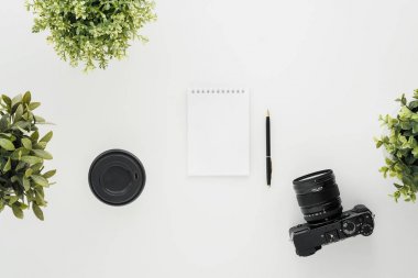 Beyaz bir masada MoCap iş fotoğrafçı. Düz aynasız kamera, birkaç lensler ve bir kalem ile bir Notebook yatıyordu.