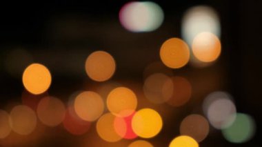 Siyah arka planda bulanık bokeh ışık lekeleri.