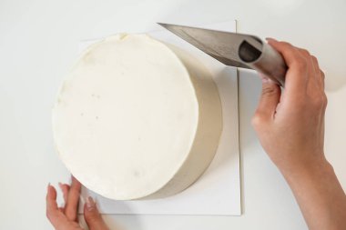 Beyaz pürüzsüz silindirik pasta boş. Şekerlemeler hamur spatulası şeklini oluşturur.