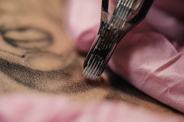 Крупный план татуировки. Процесс татуировки мастера. Розовые женские защитные перчатки . — стоковое фото