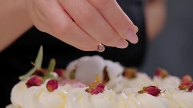 Pastacı rendelenmiş badem ve Hindistan cevizi ile pasta Sprinkles. El ve döküm kırıntıları yakın çekim.