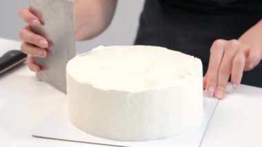 Beyaz pürüzsüz silindirik pasta boş. Şekerlemeler hamur spatulası şeklini oluşturur.