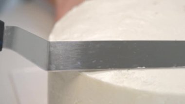 Beyaz pürüzsüz silindirik pasta boş. Şekerlemeler hamur spatulası şeklini oluşturur.