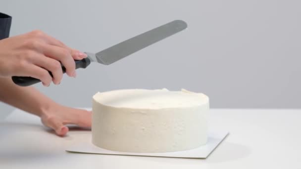 Branco liso bolo cilíndrico em branco. O confeiteiro cria a forma de uma espátula de pastelaria . — Vídeo de Stock