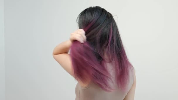 Retrato de uma jovem mulher sobre um fundo branco. Cabelo longo tingido. Ombre, coloração a cores. Lilás e azul . — Vídeo de Stock