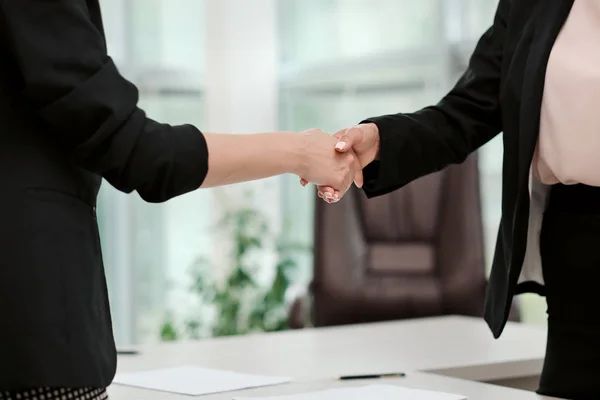 Twee mooie jonge vrouwen in business suits schudden de handen en glimlach. Een vacature inhuren. Ondertekening van de overeenkomst. Vrouwen op het werk. — Stockfoto