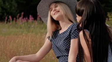 Piknik yapan üç genç çekici kız. Fotoğrafçı iki modelin aynasız kamera üzerinde fotoğraf çeker. Modeller poz ve seyretmek fotoğraf.