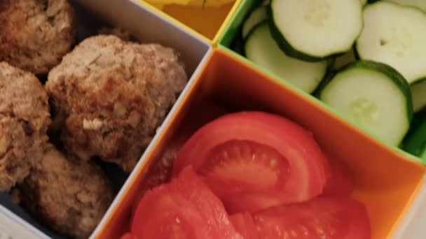 Polední box s buňkami. zelenina, okurky a rajčata, vařené brambory a masové tampóny. — Stock video