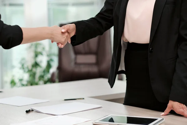 Twee mooie jonge vrouwen in business suits schudden de handen en glimlach. Een vacature inhuren. Ondertekening van de overeenkomst. Vrouwen op het werk. — Stockfoto