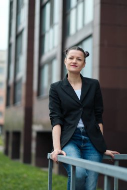 Siyah ceket ve mavi kot Genç çekici kadın binanın arka plana karşı açık poz.