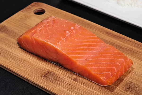 Czerwona ryba, wędzony łosoś na drewnianej desek do krojenia. Składniki do rolek i Sushi. — Zdjęcie stockowe