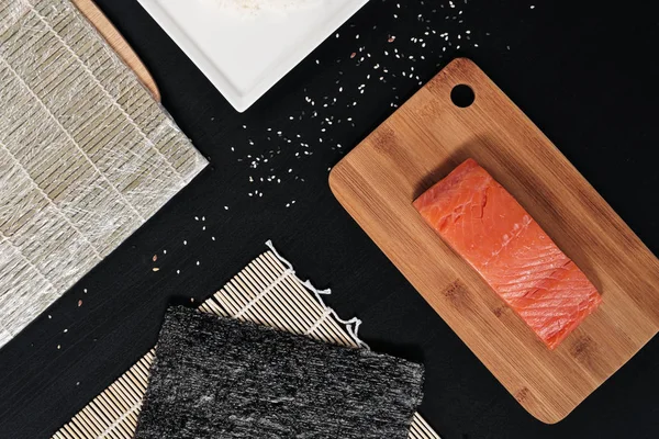 Rode vis, gerookte zalm op een houten snijplank. Ingrediënten voor broodjes en sushi. — Stockfoto