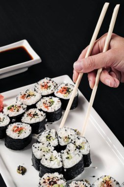 Kırmızı balık ve zencefil ile rulo seti. Masa ayarı. Siyah arka plan. Japon mutfağını pişirmek için malzemeler.