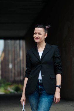 Siyah ceket ve mavi kot Genç çekici kadın binanın arka plana karşı açık poz.