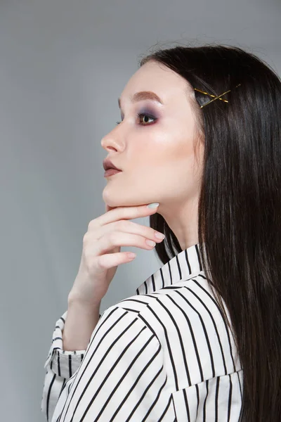 Jovem modelo de moda feminina bonita em um terno elegante de negócios em um fundo rerom. Mantém uma pilha de papéis e uma caneta . — Fotografia de Stock