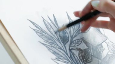 Parlak bir stüdyoda şere ve tuvaller arasında genç güzel kadın ressam. İlham ve hobi.
