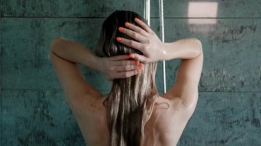 Güzel genç kadın sarışın banyoda duş takar.