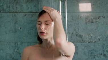 Güzel genç kadın sarışın banyoda duş takar.