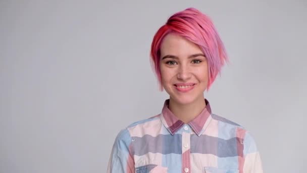 Joven hermosa chica con un corte de pelo corto pixie bob. Colorante de color de pelo, color rosa rojo. Camisa en un sótano, estilo casual . — Vídeo de stock