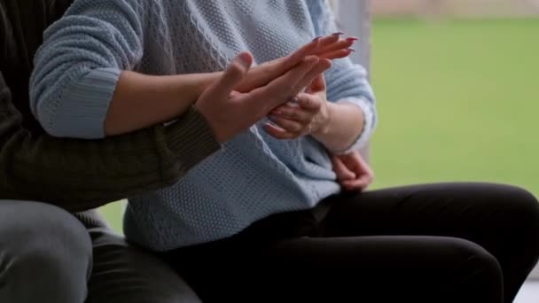 Young beautiful couple in sweaters hugging at home by the window. Short haircuts. — Stock Video