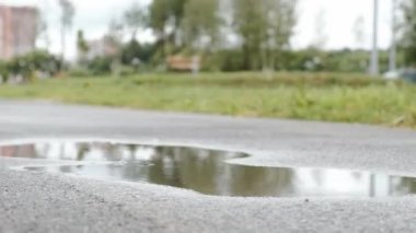 Kotlu ve spor ayakkabılı kadın bacaklarına yakın çekim. Yağmurlu bir günde su birikintilerinde yürüyorum.