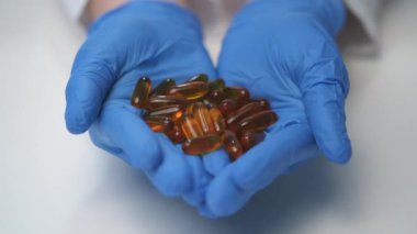 Doktorun elinde çok farklı haplar var. Bir avuç dolusu uyuşturucu. Vitaminler haplara karşı..