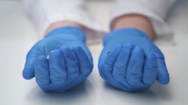 Doktorun elinde çok farklı haplar var. Bir avuç dolusu uyuşturucu. Vitaminler haplara karşı..