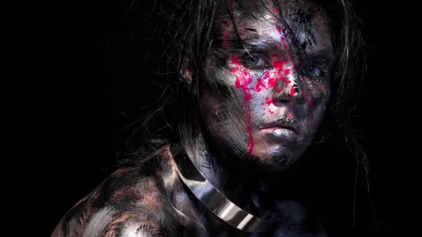 Fashion glamour portrait of beautiful young caucasian woman on black background. Bright colored creative makeup. Dramatic dark image. Effect of a dirty face with drops of blood. — Stock Video