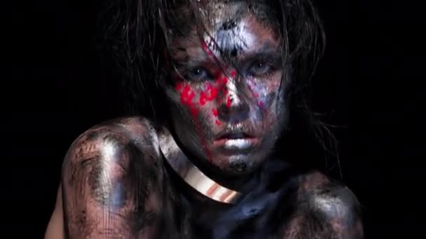 Portret pięknej młodej białej kobiety na czarnym tle. Jasny kolor twórczego makijażu. Dramatyczny mroczny obraz. Wpływ brudnej twarzy z kroplami krwi. — Wideo stockowe