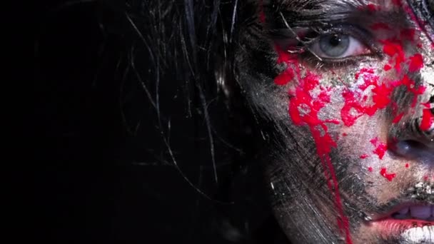 Fashion glamour portrait of beautiful young caucasian woman on black background. Bright colored creative makeup. Dramatic dark image. Effect of a dirty face with drops of blood. — Stock Video