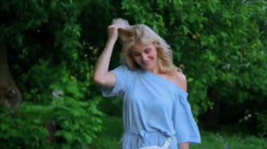 Mavi bir yaz elbisesi içinde 21 yaşında güzel bir kızın portresi. Kadın gülümsüyor. Güzel dudaklar ve gözler. Uzun kıvırcık sarı saçlar..