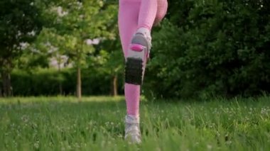 Parkta spor giyim trenlerinde rastalı saçları olan ince, güzel bir kadın. Kangoo antrenman yapıyor..