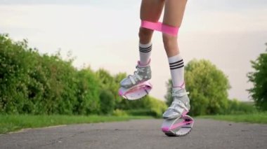 Parkta spor giyim trenlerinde rastalı saçları olan ince, güzel bir kadın. Kangoo antrenman yapıyor..