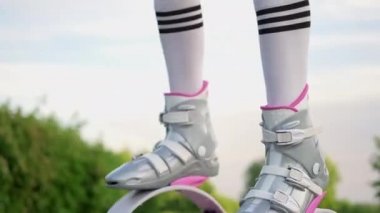 Parkta spor giyim trenlerinde rastalı saçları olan ince, güzel bir kadın. Kangoo antrenman yapıyor..