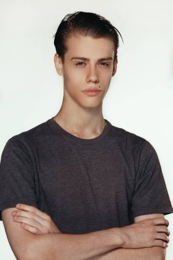 Stüdyo dalgın genç Avrupa erkek geçti ve kameraya sakin seyir silah tutmak boş duvar, poz vurdu. Beden dili. Kişi, reklam ve reklam kavramı. Poz için