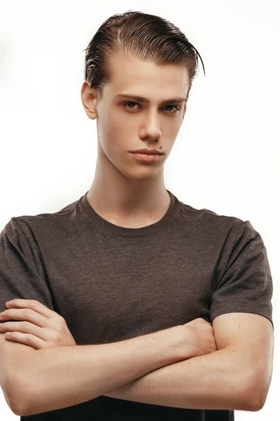 Studio shot of pensive young European male posing at blank wall, keeping arms crossed and looking at camera, brooding . Body language. People, commercials and advertisement concept. Posing for — Stock Photo, Image