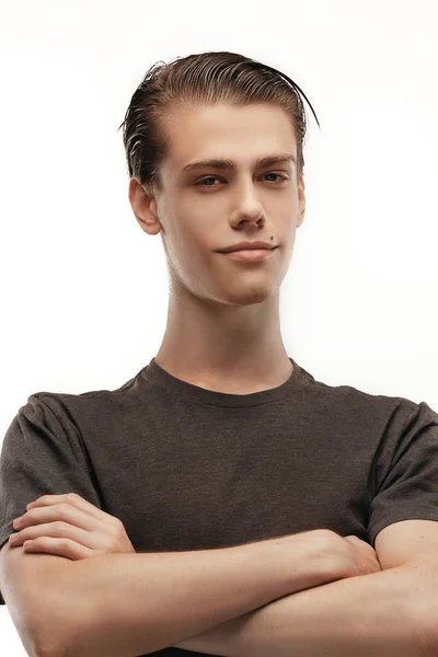 Studio shot of pensive young European male posing at blank wall, keeping arms crossed and looking at camera, confident and happy. Body language. People, commercials and advertisement concept. Posing — Stock Photo, Image