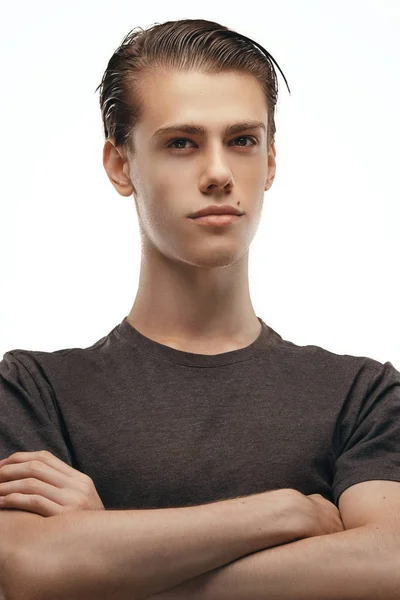 Estudio de un pensativo joven europeo posando en la pared en blanco, manteniendo los brazos cruzados y mirando por encima de la cámara, confiado y feliz. El lenguaje corporal. Concepto de personas, comerciales y publicidad —  Fotos de Stock