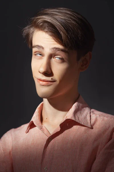 Portrait of attractive kind young man rolled his eyes in stripped shirt. Isolated on black background and looking at camera. Funny concept. — Stock Photo, Image