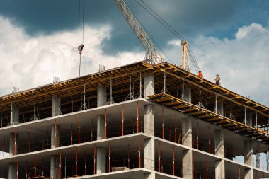 Bazı küçük işçiler ve gökyüzüne karşı vinç ile yapım aşamasında bir bina. Konsept: proje, bina, kule, iş merkezi