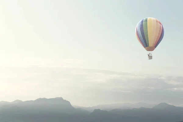 big balloon flying over mountains
