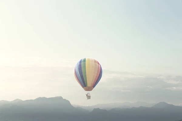 big balloon flying over mountains