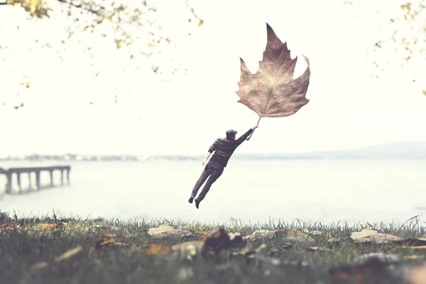 Hombre Volando Con Una Hoja Concepto Surrealista Otoñal —  Fotos de Stock