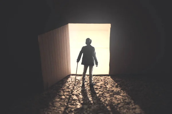 男人站在前面一个开放的明亮的门在黑暗中 — 图库照片