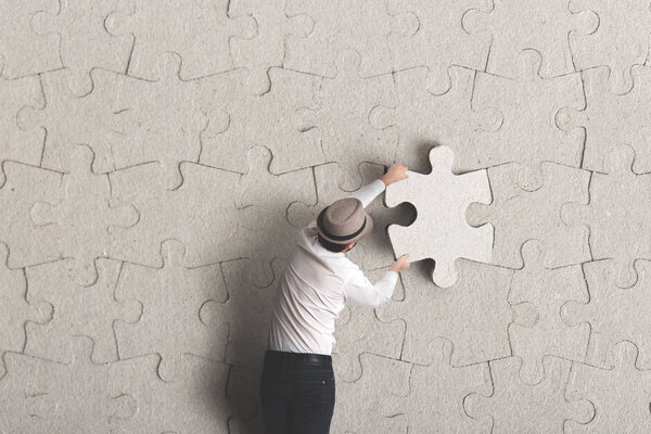 Человек ставит последний кусочек сюрреалистической концепции
