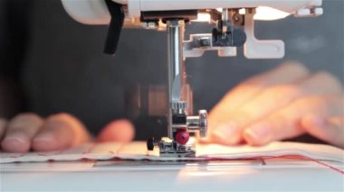 O kumaş keser ve bir makinede diker gibi bir dikiş proje üzerinde çalışan bir kadın. dikiş makinesi yakın bir bez dikiş sırasında bir makinede destekleyen bir terzi bir el kadar.