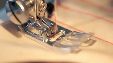 dikiş makinesi kapatın. Denim makro dikmek. Dikiş makinesi iğne yavaş çekimde bir kırmızı kalın bez diker. İplik kumaş geçer.