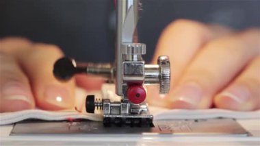 O kumaş keser ve bir makinede diker gibi bir dikiş proje üzerinde çalışan bir kadın. dikiş makinesi yakın bir bez dikiş sırasında bir makinede destekleyen bir terzi bir el kadar.